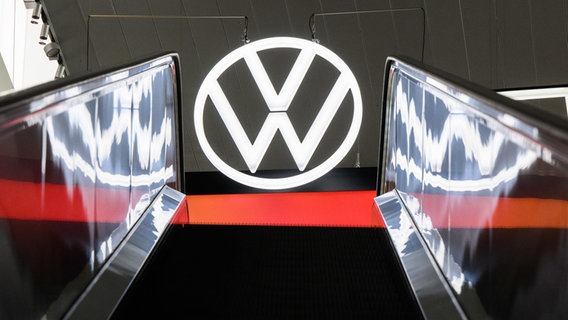 Ein Volkswagen Logo spiegelt sich in einer Rolltreppe in der Autostadt im Volkswagen Stammwerk. © dpa-Bildfunk Foto: Julian Stratenschulte/dpa