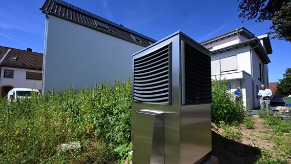 Vor einem Wohnhaus ist im Garten eine Wärmepumpe zum Heizen des Gebäudes in Betrieb. © picture alliance/dpa Foto: Bernd Weißbrod