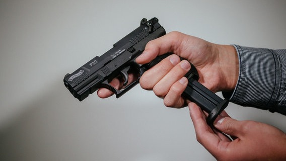 Ein Mann lädt eine Schreckschuss-Pistole «Walther P22» mit einem Magazin. © dpa Foto: Oliver Killig