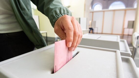 Ein Mann wirft seinen Stimmzettel für die Bundestagswahl in eine Urne. © picture alliance/dpa Foto: Julian Stratenschulte