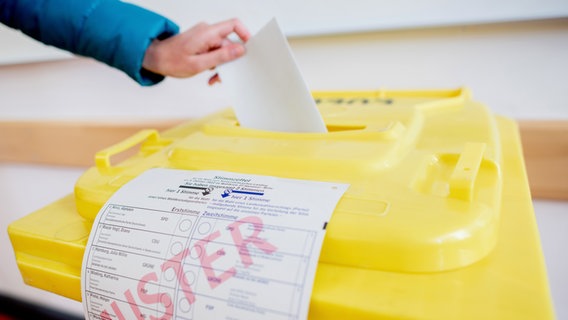 Eine Wählerin wirft in einem Wahlraum ihren Stimmzettel in eine Wahlurne. © picture allianz/dpa Foto: Hauke-Christian Dittrich