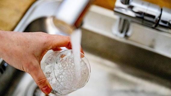 Eine Hand hält ein Glas unter einen Hahn, aus dem Wasser läuft. © picture alliance / ROBIN UTRECHT Foto: ROBIN UTRECHT
