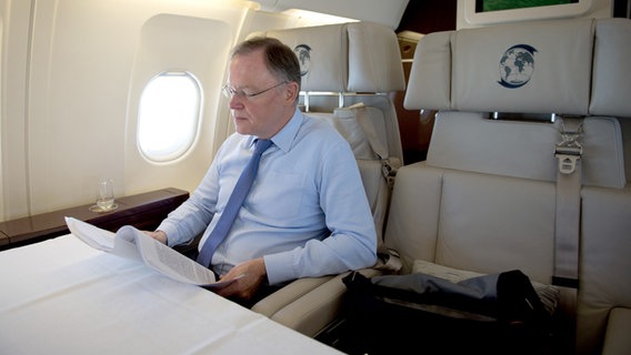 Ministerpräsident Stefan Weil sitz in einem Flugzeug und arbeitet. © dpa Bildfunk/picture-alliance Foto: Jochen Lübke