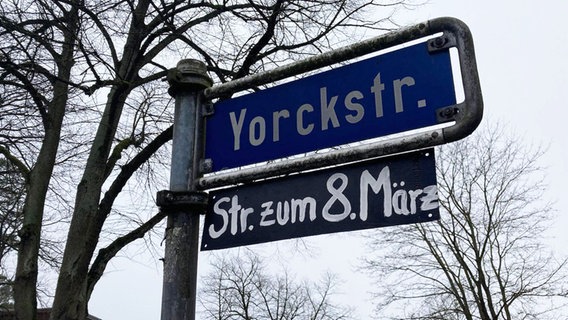 Unter dem Straßenschild der Yorckstraße in Lüneburg ist ein Schild mit der Aufschrift "Str. zum 8. März" angebracht. © fem.trails, VVN/BdA Lüneburg 
