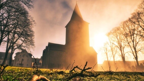Blick auf Kirche bei Sonnenaufgang. © NDR Foto: Domenic Schlinge