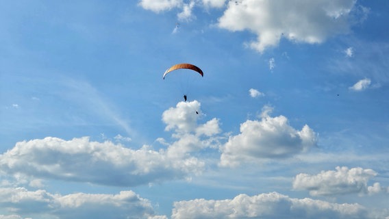 Ein Gleitschirmflieger ist am Himmel über Alfeld zu sehen. © NDR Foto: Jutta Habenicht-Ive
