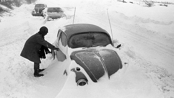 Eine Person steht neben einem eingeschneiten VW-Käfer. © dpa-Bildfunk Foto: Werner Schilling