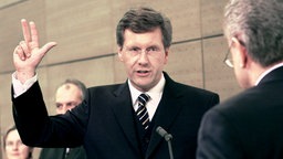 Der damals neue niedersächsische Ministerpräsident Christian Wulff (CDU) leistet am 4.3.2003 im Landtag von Hannover seinen Amtseid vor dem neuen Landtagspräsicenten Jürgen Gansäuer.  © picture-alliance / dpa Fotoreport Foto: Wolfgang Weihs