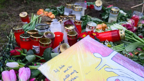 Blumen und Kerzen liegen an einer Tannenbaumschonung in Wunstorf-Blumenau in der Region Hannover. © dpa-Bildfunk Foto: Julian Stratenschulte/dpa