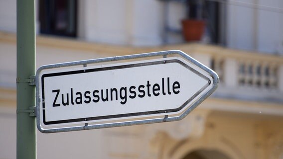 Das Bild zeigt ein Straßenschild, welches den weg zur Zulassungsstelle illustriert. © picture-alliance Foto: Sören Stache