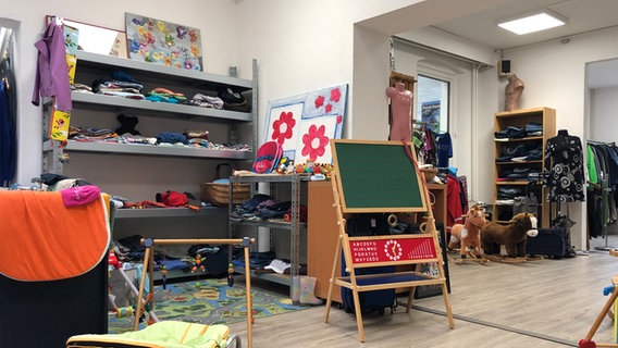 Kinderkleidung und Spielzeug in einem Second-Hand-Geschäft. © NDR Foto: Julia Barthel
