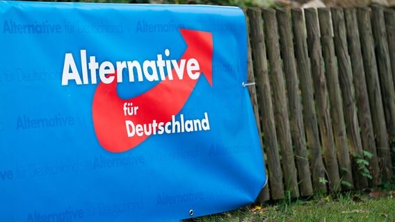 Ein Plakat mit dem Logo der Partei Alternative für Deutschland (AfD) ist beim Politischen Frühschoppen auf dem Volksfest Gillamoos im Schlossgarten angebracht. © picture alliance/dpa | Nicolas Armer Foto: Nicolas Armer