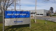 Ein Firmenschild von Axel Springer und Prinovis am Eingang des Geländes. © Johannes Tran Foto: Johannes Tran