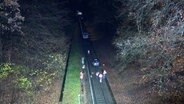 Ein Auto steht auf den Gleisen, daneben stehen Feuerwehreinsatzkräfte © TV News Kontor 