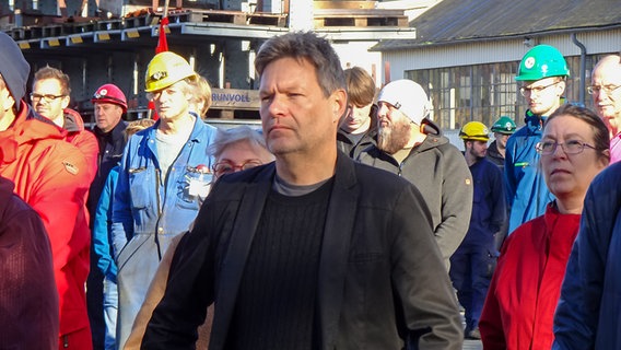 Robert Habeck steht neben Werftmitarbeitern bei einer Aktion der IG Metall auf dem Werftgelände der FSG in Flensburg. © NDR Foto: Peer-Axel Kroeske
