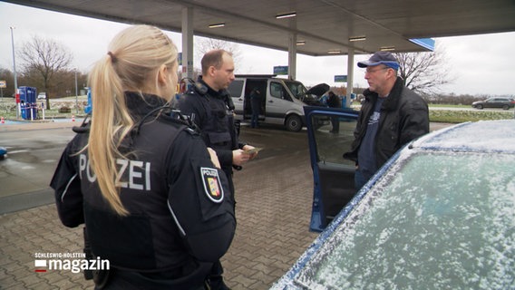 Polizisten führen eine Fahrzeugkontrolle durch. © NDR 