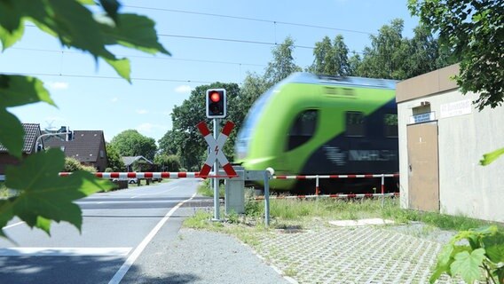 Ein vorbeifahrender Regionalzug an einem Bahnübergang. © Daniel Kummetz Foto: Daniel Kummetz