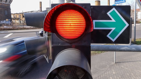 Ein Grüner Pfeil hängt neben einer roten Ampel und erlaubt das Abbiegen trotz Rotlicht. © picture alliance/dpa Foto: Jan Woitas