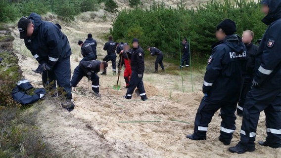 Mehrere Polizisten suchten mit Werkzeugen im Sand nach einem Vermissten. © Polizei Flensburg Foto: Polizei Flensburg
