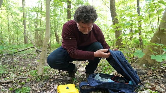 Florian Gloza-Rausch breitet seine Ausrüstung im Wald aus © NDR Foto: Elin Halvorsen