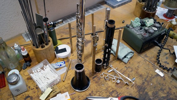 Viele Werkzeuge und auseinander gebaute Instrumente liegen auf dem Arbeitsplatz im Holzblasinstrumenten-Studio. © NDR Foto: Robert Tschuschke