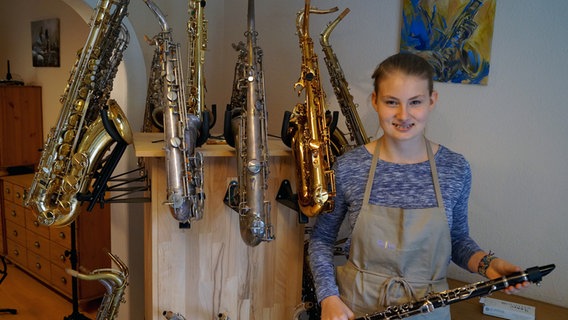 Die Auszubildende Sarah Kragge mit einer Auswahl verschiedener Blasinstrumente. © NDR Foto: Robert Tschuschke