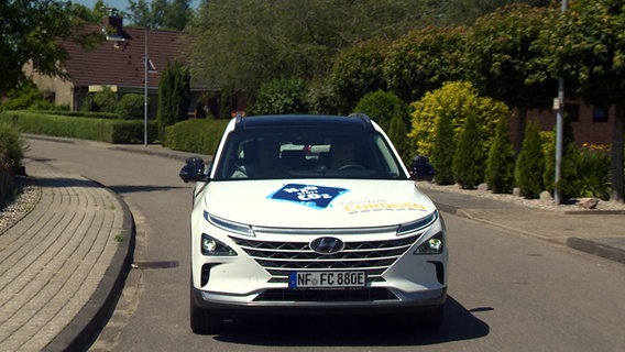 Ein Wasserstoffauto der Fahrschule Cordsen ist in Leck auf einer Straße unterwegs. © NDR 