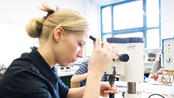 Auszubildende zum Augenoptiker im Bildungs- und Technologiezentrum der Handwerkskammer Berlin, Brillengläser werden für das Einsetzen in das Gestell durchbohrt. © picture alliance / Keystone | Jochen Zick Foto: Jochen Zick