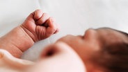 Ein Neugeborenes liegt in einem Bett in einem Krankenhaus. © imago images Foto: Westend61