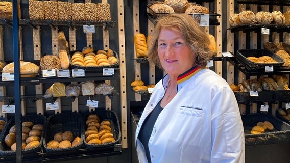Eine Bäckerin steht vor ihrem Sortiment. © NDR Foto: Andrea Schmidt