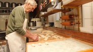 Ein Bäcker verarbeitet Teig. © NDR Foto: Marian Schäfer