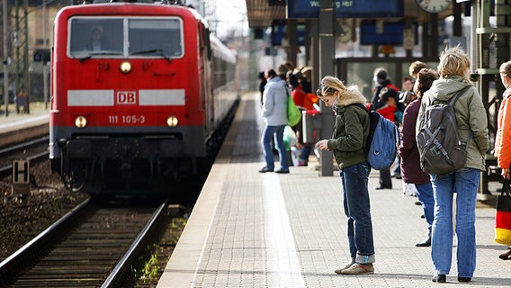 Eine Schülerin wartet auf den einfahrenden Zug. © dpa Foto: Wolfram Steinberg