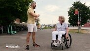 NDR Reporter Philipp Jeß unterhält sich mit einer Dame im Rollstuhl. © NDR 