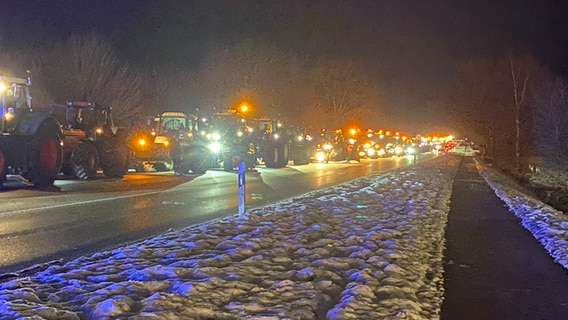 Eine Reihe von Traktoren steht in der Dunkelheit auf einer Straße. © André Schnoor Foto: André Schnoor
