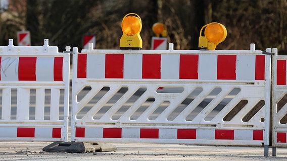 Eine Straße ist mit Warnbaken und einem Zaun abgesperrt. © NDR Foto: Pavel Stoyan