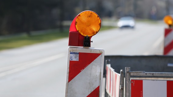 Baustellenbaken und Absperrzaun stehen am Straßenrand. © NDR Foto: Pavel Stoyan