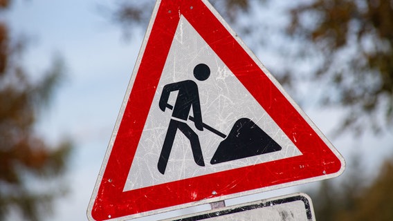 Ein zerkratztes Schild Gefahrzeichen Arbeitsstelle (Zeichen 123) mit dem Piktogramm eines Bauarbeiters zur Beschilderung einer Baustelle. © dpa Foto: Stefan Sauer