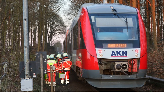 Die Regionalbahn steht auf den Gleisen, Rettungskräfte stehen daneben. © NDR Foto: Florian Sprenger