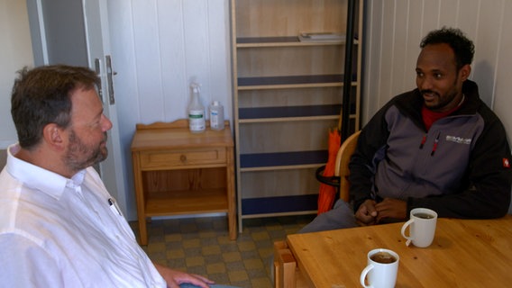 Ein Migrant in einem Gespräch mit einem Mann bei der Migrationsberatung. © NDR 