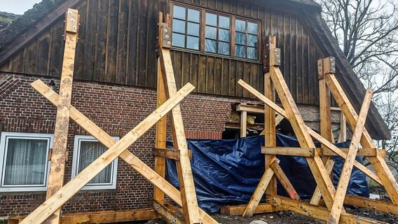 Bei einem Wohnhaus sind Stützbalken installiert, nachdem ein Betonlaster hingekracht war. © NDR Foto: Laura Albus