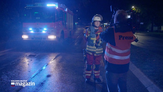 Ein Blaulichtreporter filmt einen Pressesprecher der Feuerwehr. © NDR 