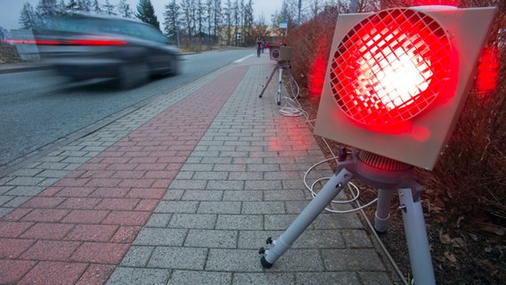 Ein roter Blitz leuchtet, während ein Auto an ihm vorbeifährt. © dpa-Bildfunk Foto: Jens Büttner