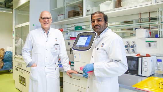 Prof. Dr. Nikolas von Bubnoff und Dr. Sivahari Prasad Gorantla mit einem Gerät, das den molekularbiologischen Nachweis von Proteinen ermöglicht. © UKSH 