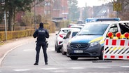 Kiel: Ein Polizist sperrt im Stadtteil Elmschenhagen die Zufahrt zu einem Wohngebiet ab. Wegen der Entschärfung von vier Fliegerbomben aus dem Zweiten Weltkrieg. © dpa-Bildfunk Foto: Daniel Bockwoldt