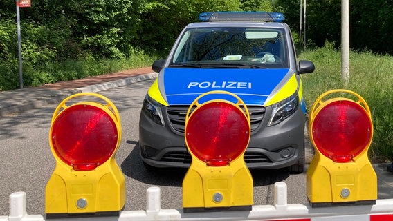 Ein Streifenwagen der Polizei steht hinter einer Straßenabsperrung. © NDR Foto: Eike Köhler