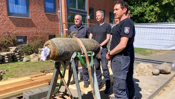 Mitarbeiter des Kampfmittelräumdienstes stehen neben einem entschärften Blindgänger in Kiel. © NDR Foto: Eike Köhler