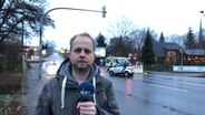 NDR-Reporter steht vor einer Straße und spricht in eine Kamera. © NDR 