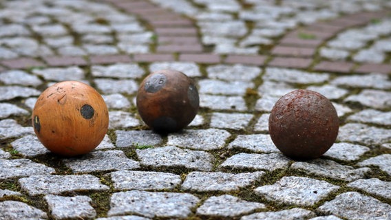 Drei Kugeln für die verschiedenen Boßel-Disziplinen. Sie sind aus unterschiedlichem Material, teilweise aus Holz und teilweise aus Metall. © NDR Foto: Frank Goldenstein