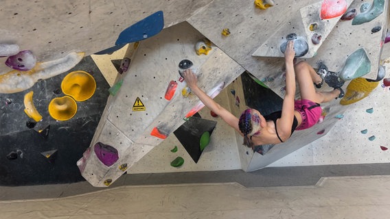 Eine Frau hängt an einer Kletterwand. © NDR Foto: Lena Haamann