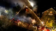 Feuerwehrleute löschen ein brennendes Haus. © dslrnews / TVNewskontor 